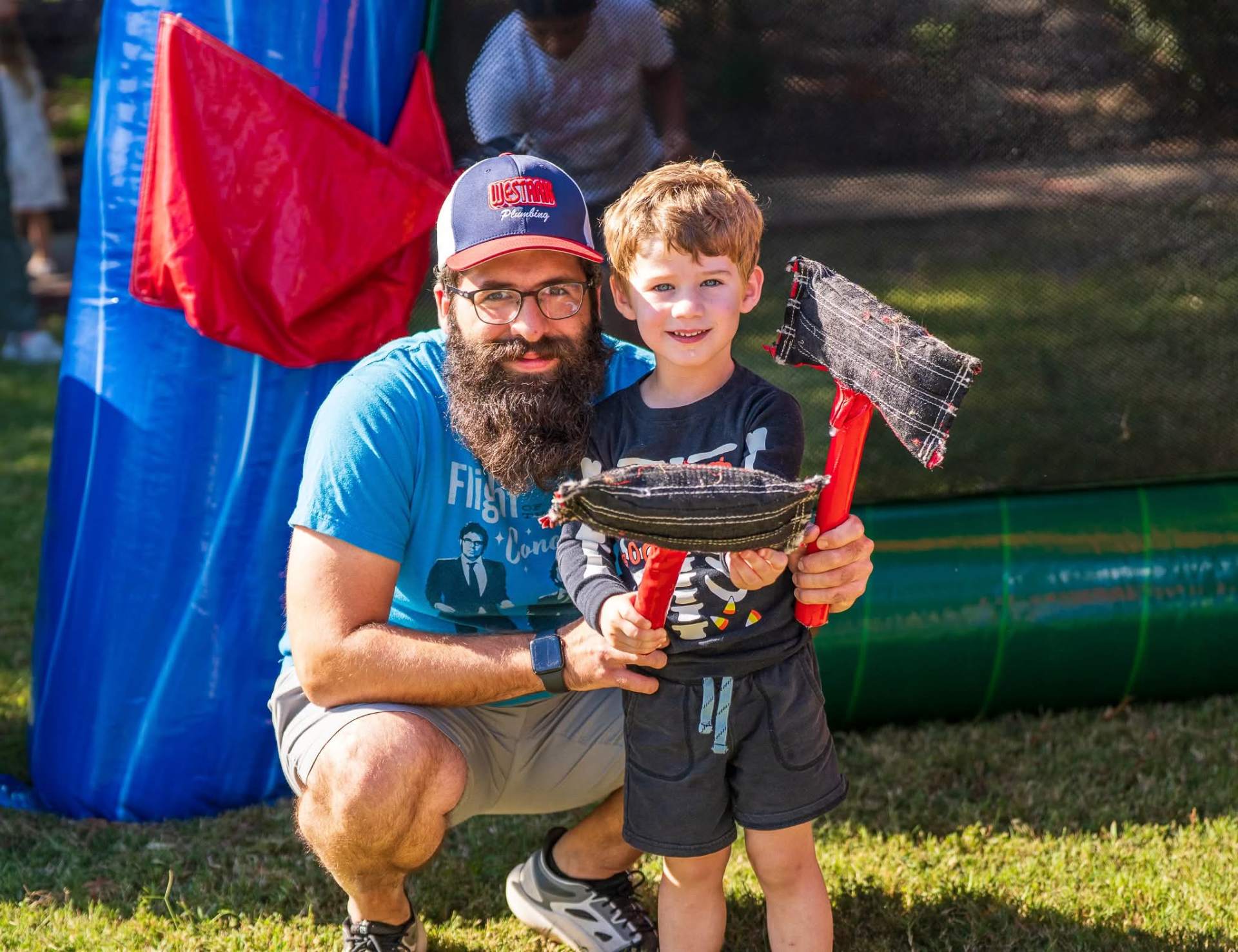 Father and son enjoying inflatable games at Fort Smith event